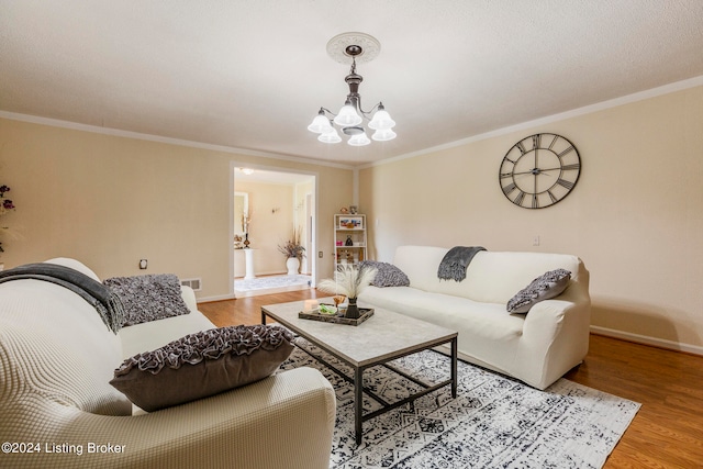 living room with hardwood / wood-style flooring, crown molding, and a chandelier