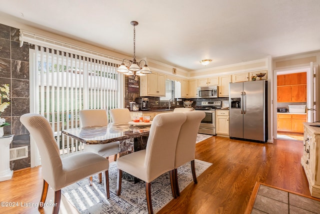 dining space featuring a wealth of natural light, a chandelier, wood-type flooring, and sink