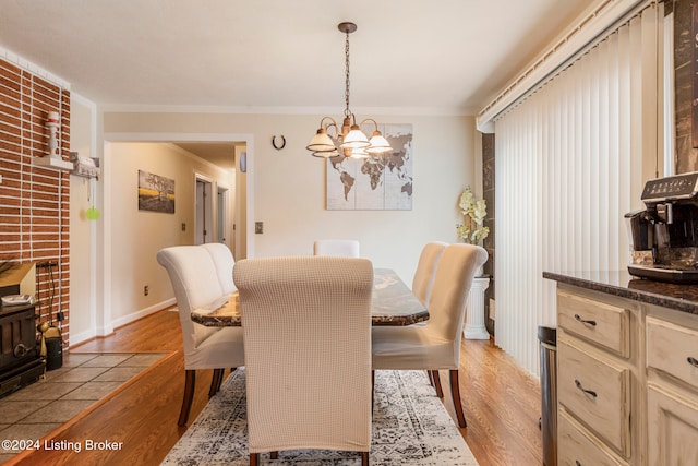 dining room with ornamental molding, light hardwood / wood-style flooring, and a notable chandelier