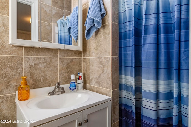 bathroom featuring vanity, tile walls, and decorative backsplash