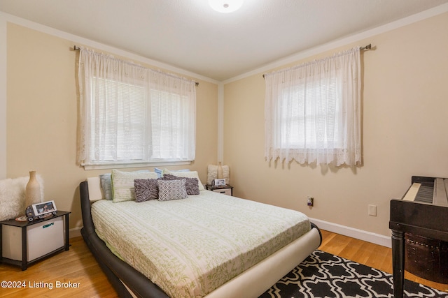 bedroom with ornamental molding and wood-type flooring