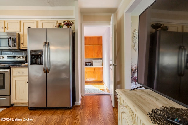 kitchen featuring wood-type flooring, light brown cabinetry, and appliances with stainless steel finishes