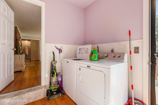 washroom with washing machine and clothes dryer and light hardwood / wood-style floors