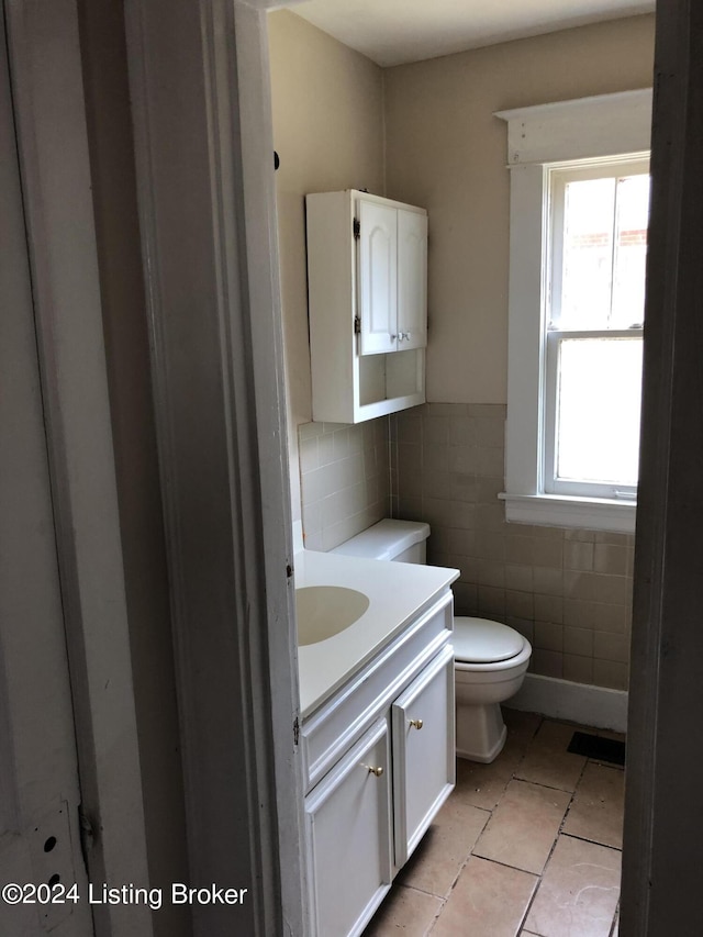 bathroom featuring tile walls, tile patterned floors, vanity, and toilet