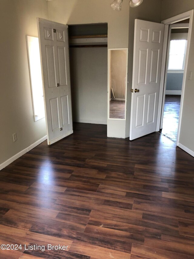 unfurnished bedroom with dark wood-type flooring