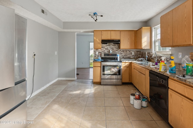 kitchen with light tile patterned floors, a textured ceiling, appliances with stainless steel finishes, and sink