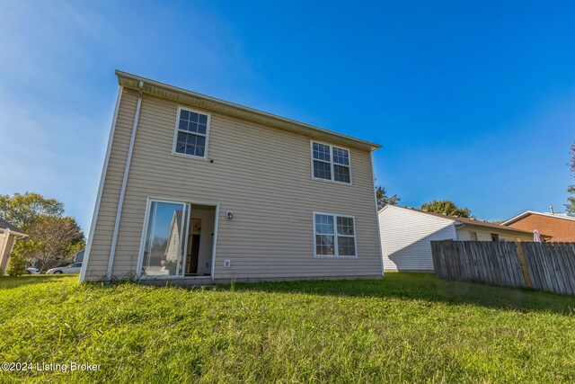 rear view of property featuring a lawn