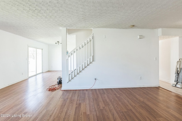 spare room with a textured ceiling and hardwood / wood-style flooring