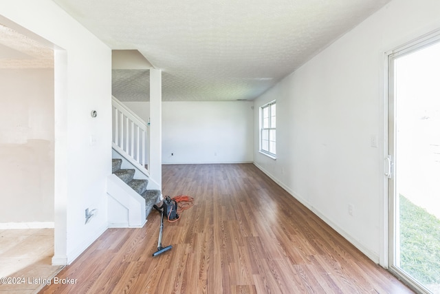 unfurnished living room featuring a textured ceiling and hardwood / wood-style flooring