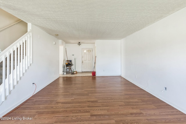 empty room with wood-type flooring and a textured ceiling