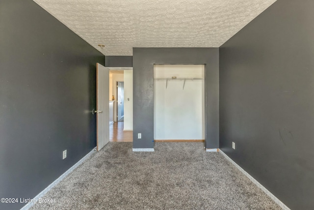 unfurnished bedroom featuring a closet, a textured ceiling, and carpet flooring