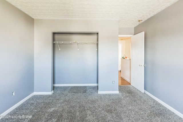 unfurnished bedroom with a textured ceiling, a closet, and carpet floors