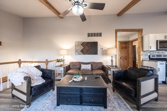 living room with ceiling fan, beam ceiling, and dark wood-type flooring