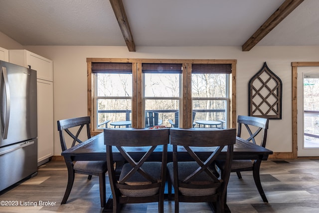 dining room with beam ceiling, a textured ceiling, and dark hardwood / wood-style flooring