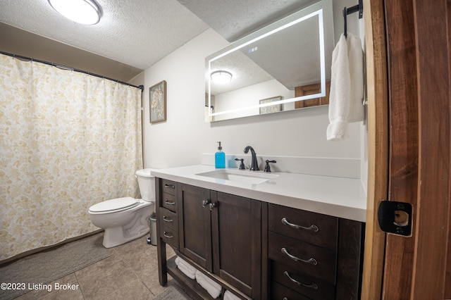 bathroom featuring a textured ceiling, tile patterned flooring, vanity, and toilet