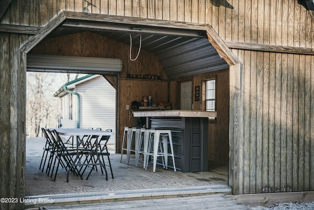 exterior space featuring hardwood / wood-style flooring, wooden walls, and vaulted ceiling