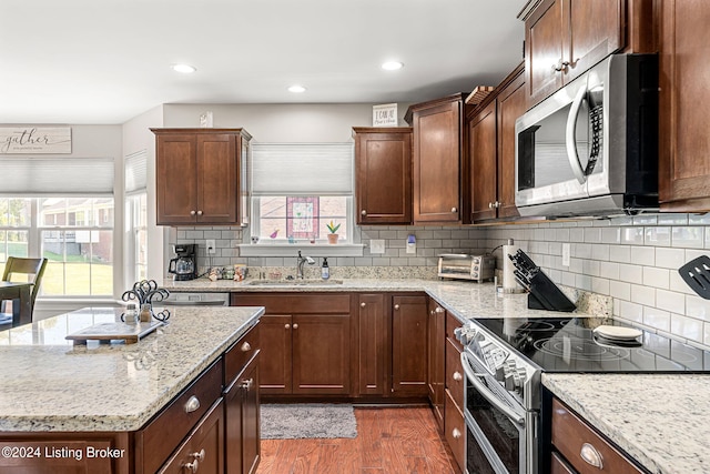 kitchen featuring backsplash, appliances with stainless steel finishes, dark hardwood / wood-style floors, and sink