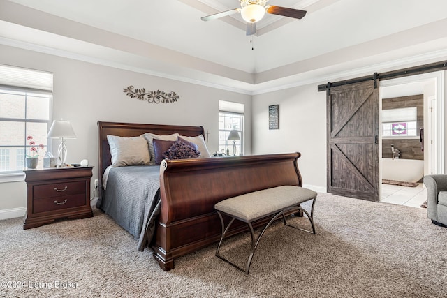 carpeted bedroom with a barn door, ornamental molding, and ceiling fan