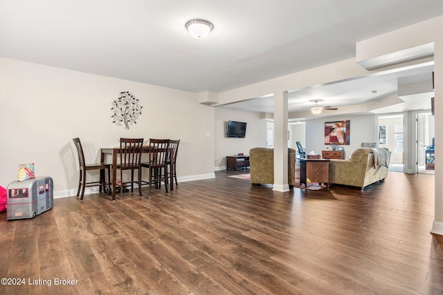 living room featuring ceiling fan and dark hardwood / wood-style floors