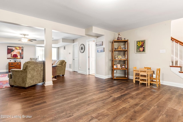 living room featuring dark hardwood / wood-style flooring and ceiling fan