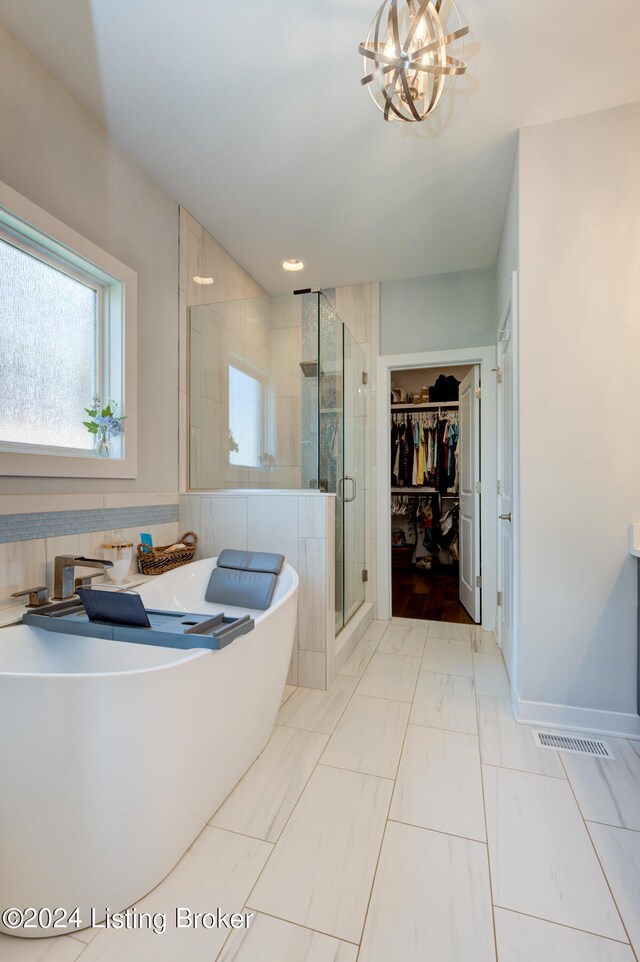 bathroom featuring an inviting chandelier and a shower with shower door