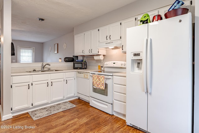 kitchen with white cabinets, light hardwood / wood-style floors, sink, and white appliances