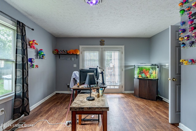 home office with a textured ceiling, dark hardwood / wood-style floors, and plenty of natural light