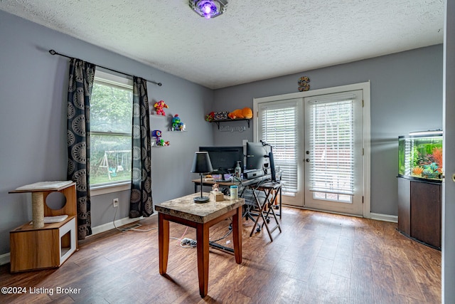 office space with a textured ceiling, hardwood / wood-style flooring, and french doors