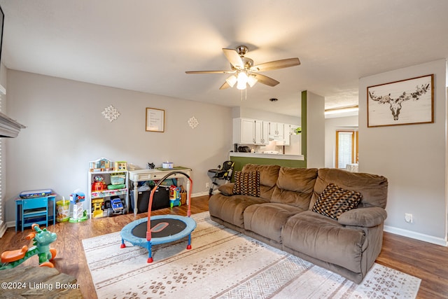 living room featuring wood-type flooring and ceiling fan