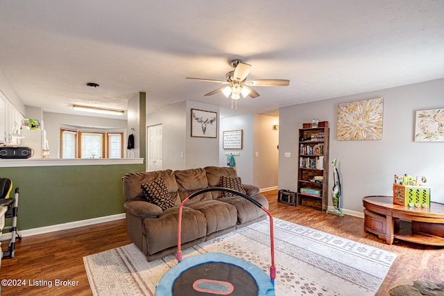 living room featuring ceiling fan and dark hardwood / wood-style floors