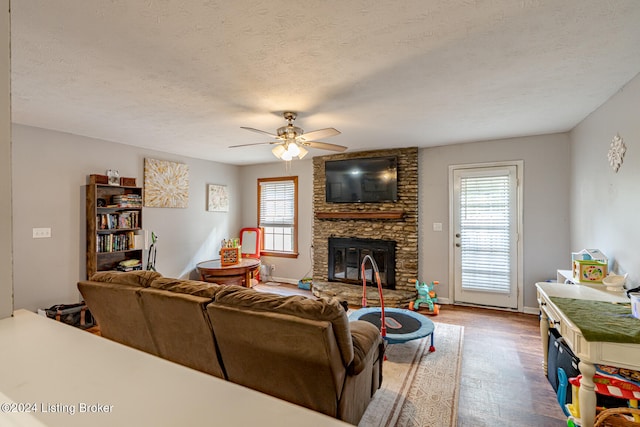 living room featuring ceiling fan, a textured ceiling, and hardwood / wood-style floors