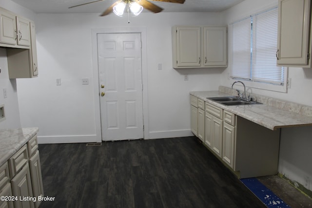 kitchen with light stone counters, ceiling fan, dark wood-type flooring, and sink