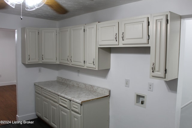 washroom featuring hookup for a washing machine, dark hardwood / wood-style floors, ceiling fan, and cabinets