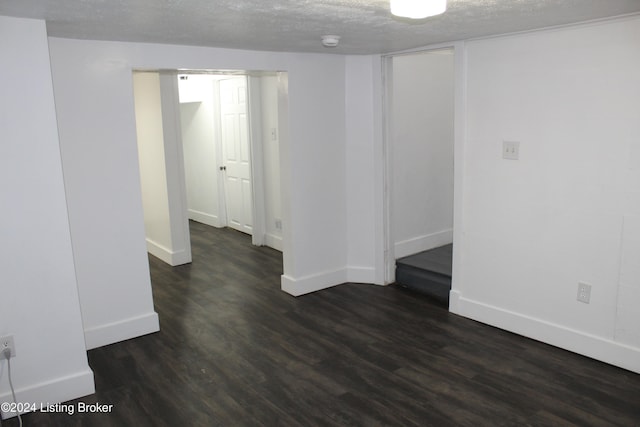 empty room featuring a textured ceiling and dark hardwood / wood-style flooring