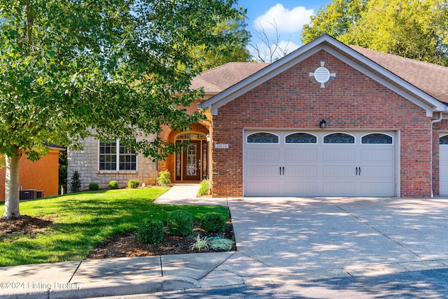 view of front of house featuring cooling unit, a front lawn, and a garage