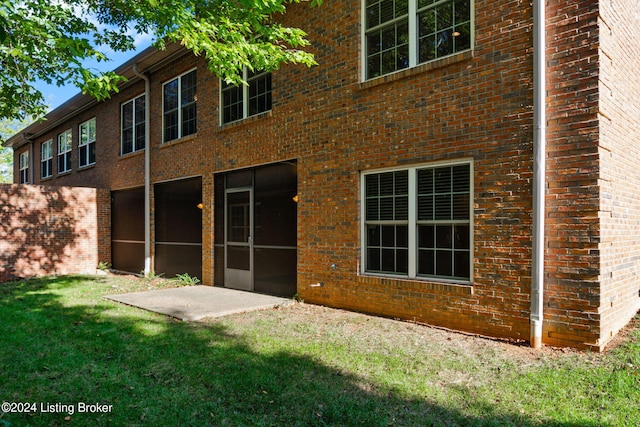 back of property with a patio area and a yard