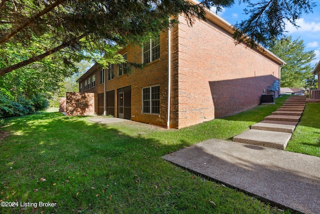 view of property exterior with central AC unit and a yard