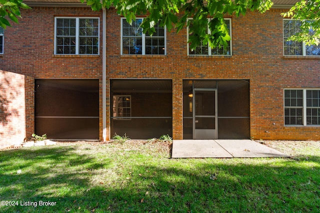 back of house with a sunroom, a yard, and a patio