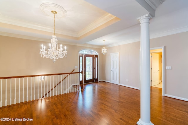 entryway with an inviting chandelier, crown molding, dark wood-type flooring, and a tray ceiling