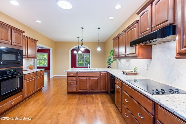 kitchen with black appliances, light hardwood / wood-style flooring, decorative light fixtures, kitchen peninsula, and a chandelier