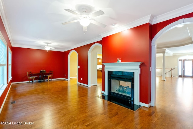 unfurnished living room with a wealth of natural light, wood-type flooring, and ornamental molding