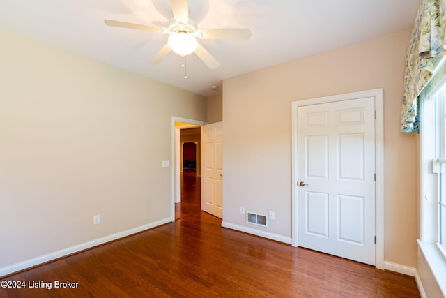 unfurnished bedroom with ceiling fan and dark hardwood / wood-style flooring