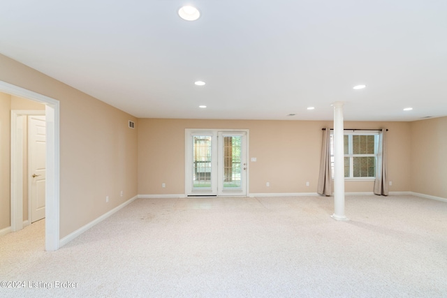 spare room featuring light colored carpet and ornate columns