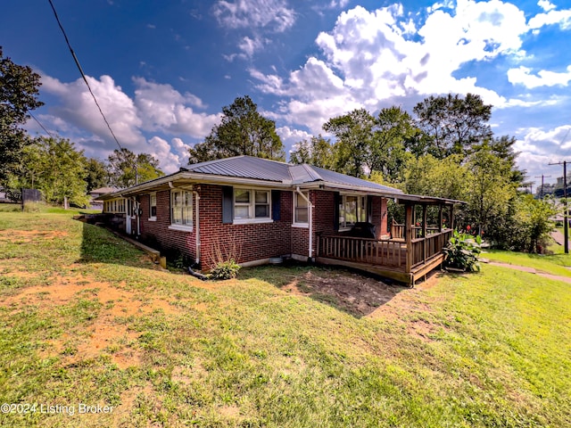 view of front of home featuring a front yard and a wooden deck