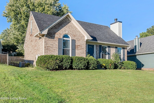 view of front of home with cooling unit and a front lawn