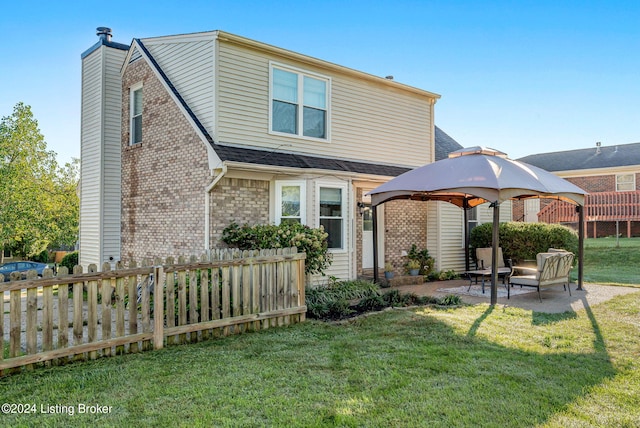 rear view of house with a lawn, a gazebo, and a patio