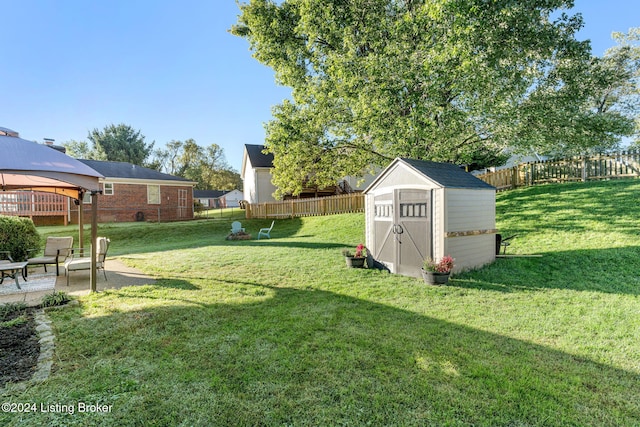 view of yard featuring a gazebo, a storage shed, and a patio