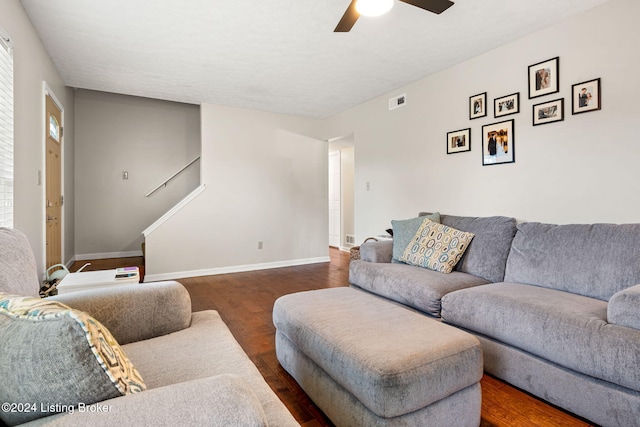 living room featuring ceiling fan and dark wood-type flooring