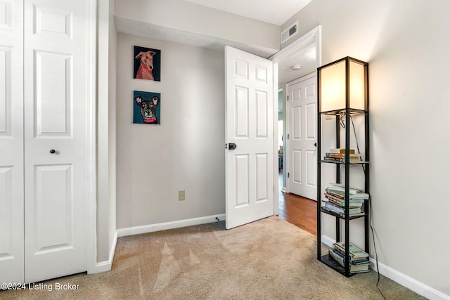 unfurnished bedroom with light carpet and a closet