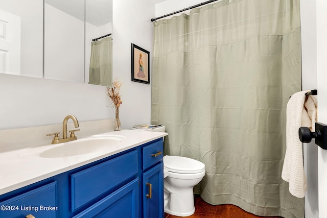 bathroom featuring walk in shower, vanity, hardwood / wood-style floors, and toilet